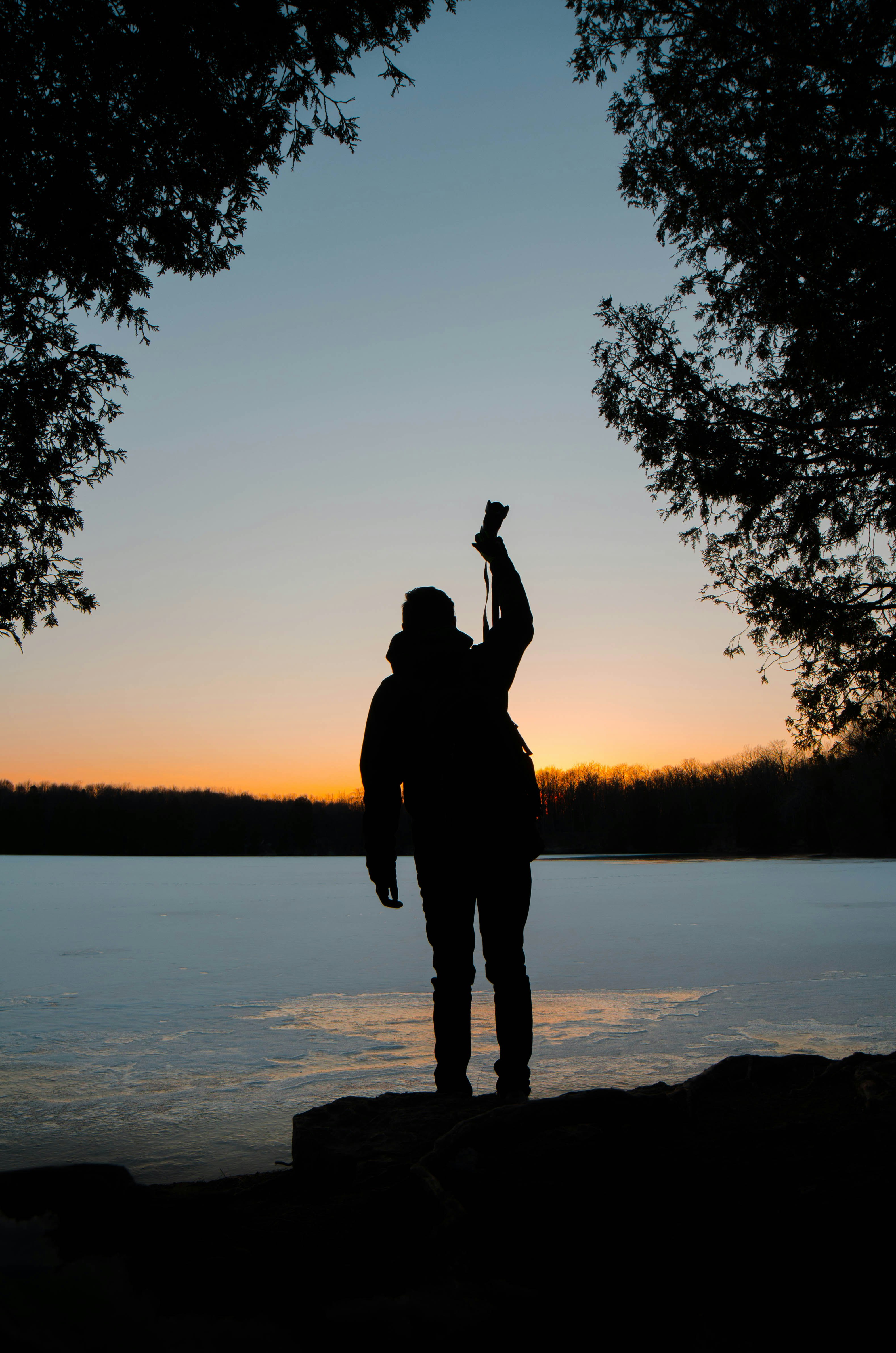 silhouette of person raising his right hand